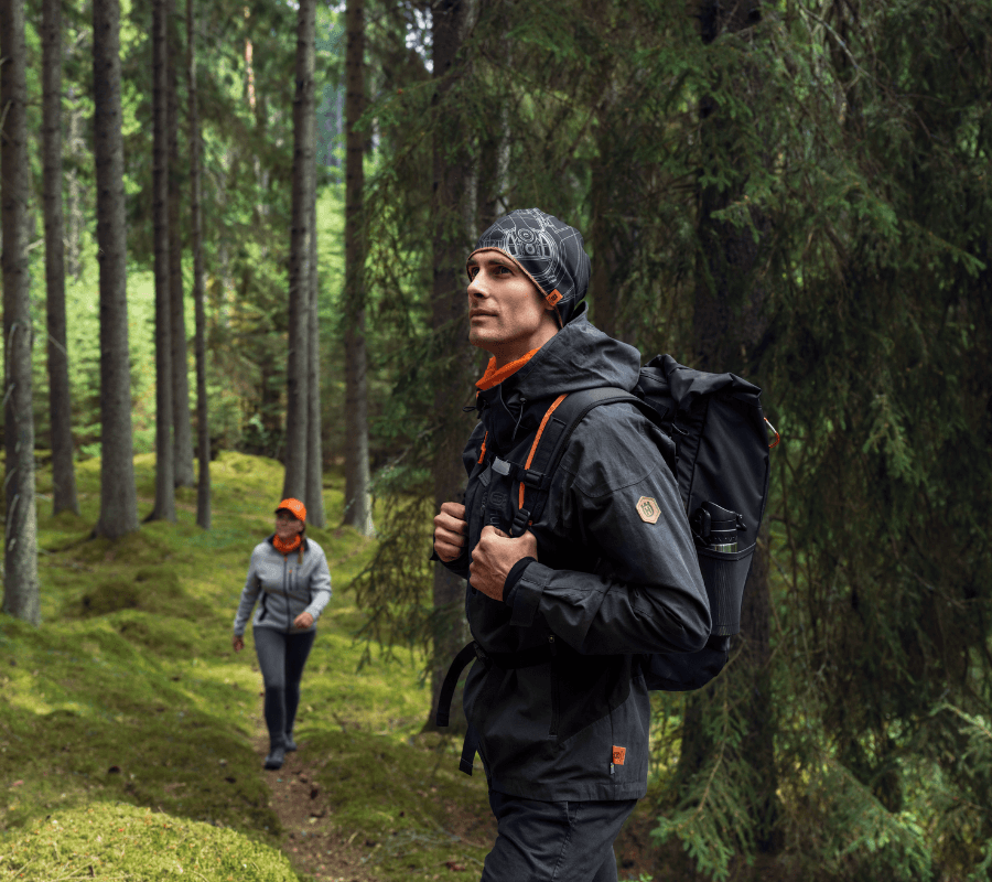 couple hiking in the forest wearing husqvarna clothing