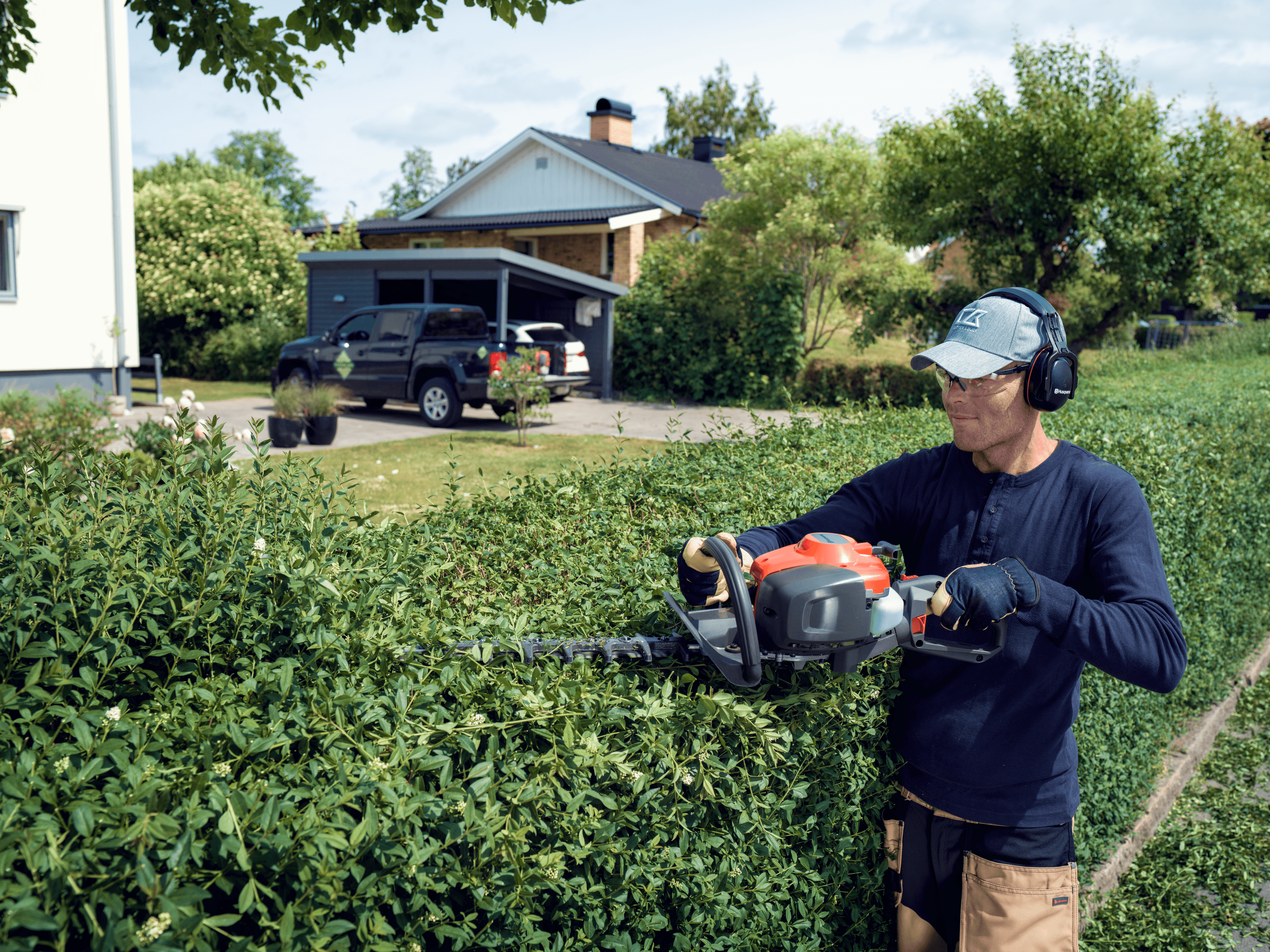 man holding polesaw whilst cutting tree